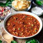 large bowl of Panera turkey chili with a wooden spoon and bowls of toppings
