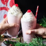 people doing a toast with two peppermint milkshakes