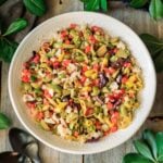 white bowl of olive salad with two black spoons