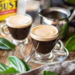 two cups of Cuban coffee with a creamer