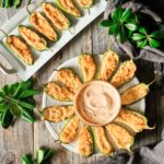 baked jalapeño poppers on two white plates
