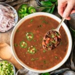 person holding a spoonful of black bean soup