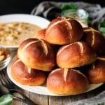stack of pretzel buns on a white plate