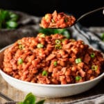 person holding a spoonful of baked beans