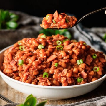 person holding a spoonful of baked beans