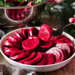 person holding a slice of beet on a fork