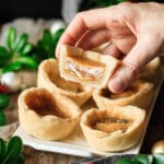 person holding half of a butter tart