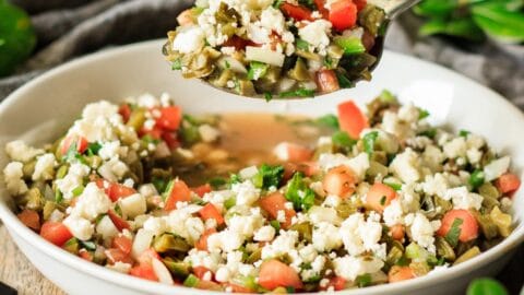 person holding a spoonful of nopales salad
