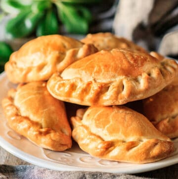 stack of chicken empanadas on a white plate