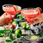 people doing a toast with two virgin strawberry margaritas