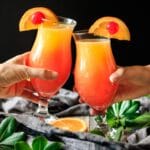 people doing a toast with tequila sunrise mocktails