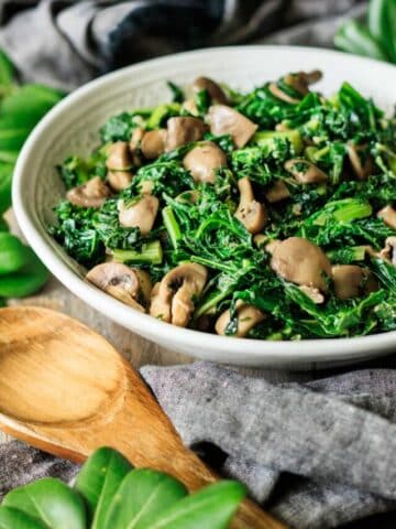 sauteed kale with mushrooms in a white bowl