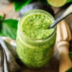 jar of avocado cilantro dressing with a black spoon