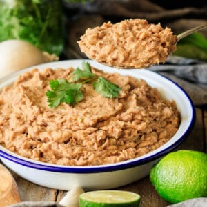 person holding a spoonful of refried beans