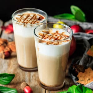 two apple crisp macchiatos with fall foliage