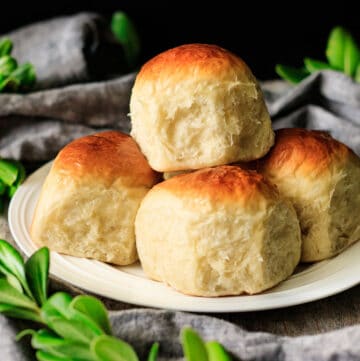 stack of milk bread rolls on a white plate