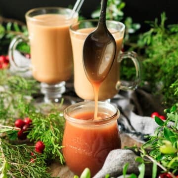 person drizzling a spoonful of caramel sauce into a jar