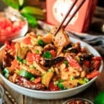 person holding a piece of kung pao chicken