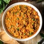 bowl of Moroccan lentil stew with a wooden spoon