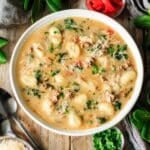 bowl of sausage gnocchi soup with toppings