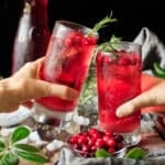people doing a toast with two sparkling cranberry mocktails