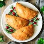 three baked turkey pasties on a white plate