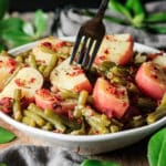 person taking a forkful of green beans and potatoes