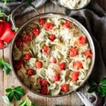 pan of alfredo basil sauce with tomatoes