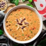 bowl of chicken tortilla soup with a wooden spoon