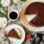 slice of sachertorte on a white plate with a cup of coffee