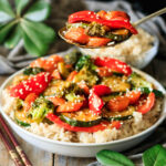 person holding a spoonful of vegetable stir fry