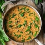 skillet of green curry lentils with greenery.