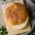 baked muffaletta bread sliced in half on a cutting board.