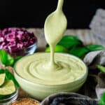 drizzling a spoonful of avocado lime ranch into a bowl.