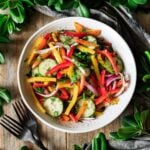 white bowl of bell pepper salad with two forks.