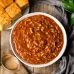 bowl of Brunswick stew with a wooden spoon.