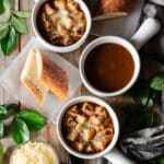 three bowls of French onion soup with bread and cheese.