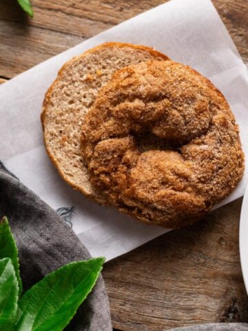 sliced Panera cinnamon crunch bagel on parchment paper.