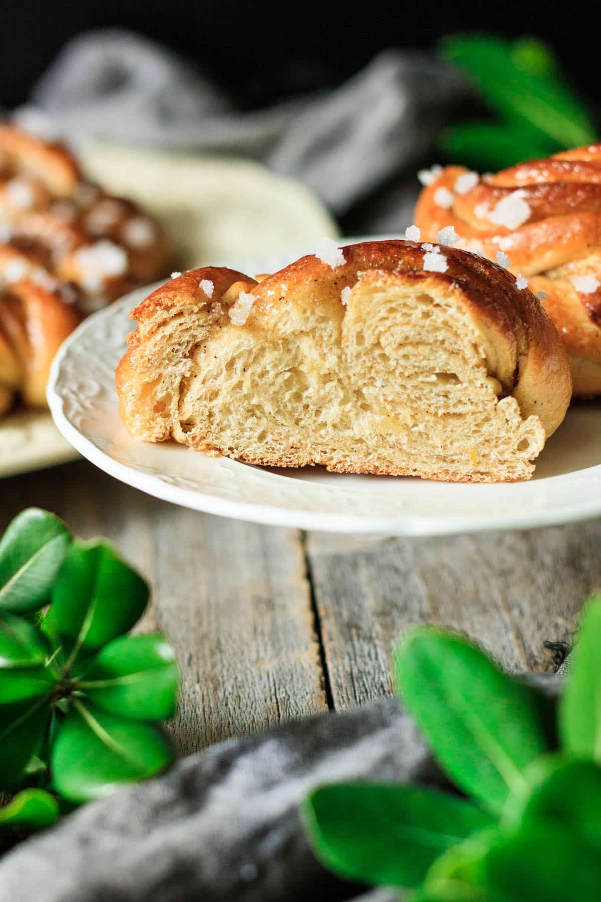 half of a cardamom bun on a small white plate.