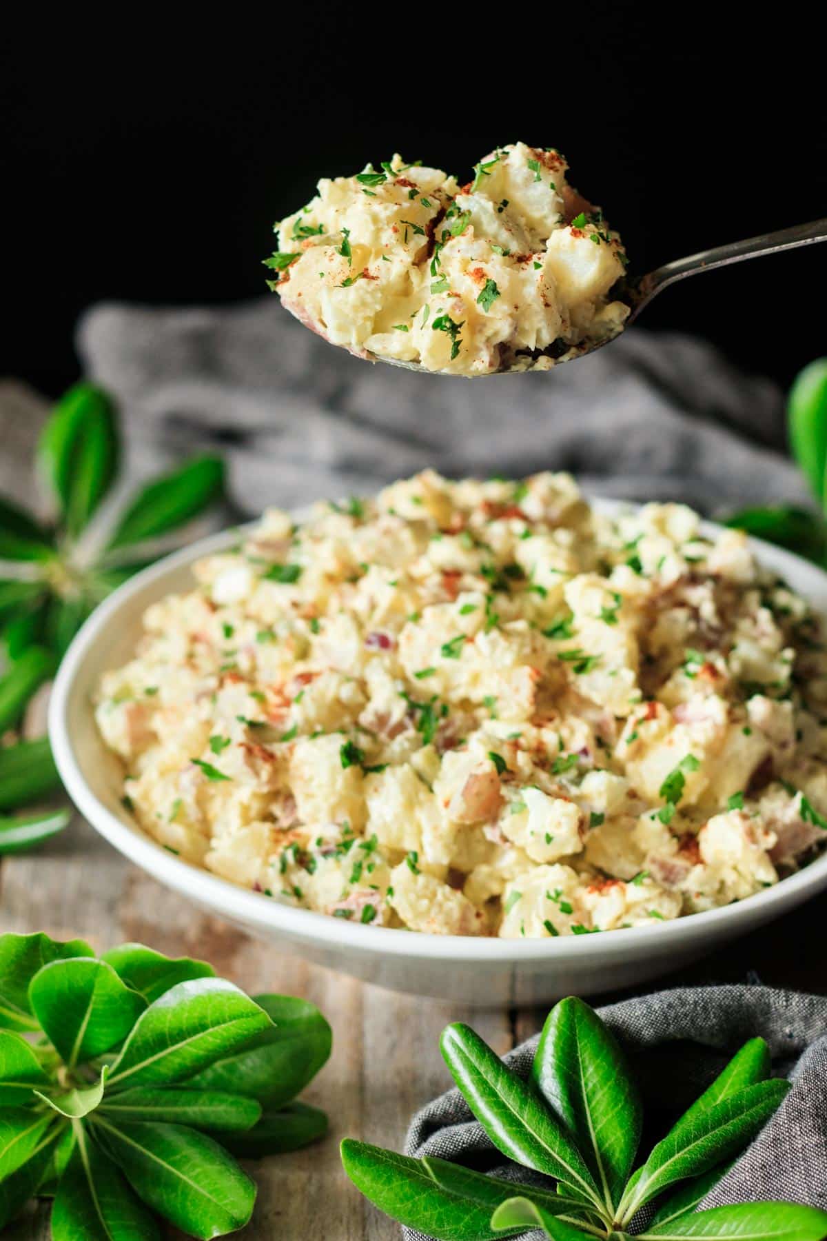 holding a large spoonful of Southern potato salad.