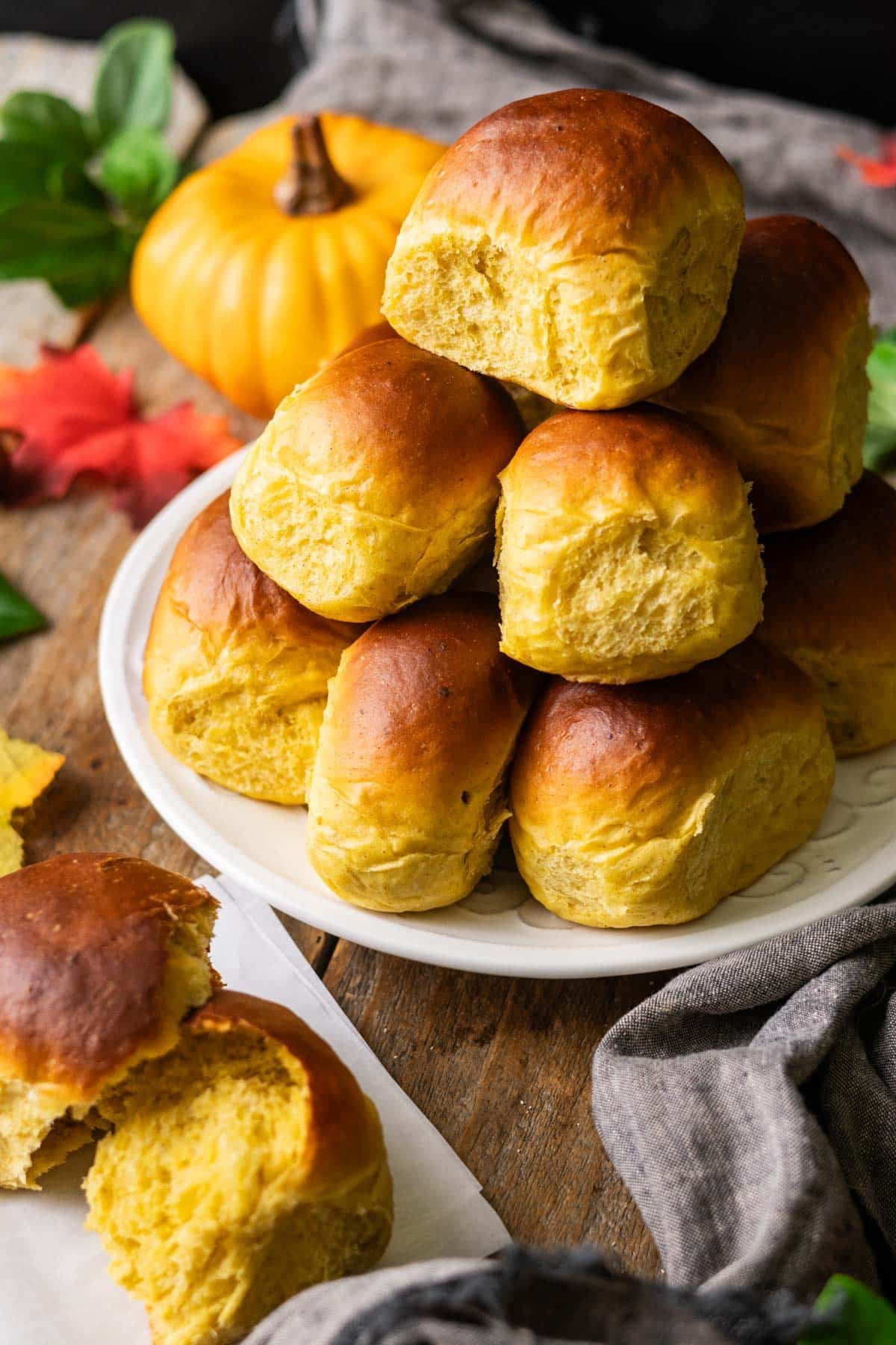 stack of pumpkin dinner rolls on a plate.