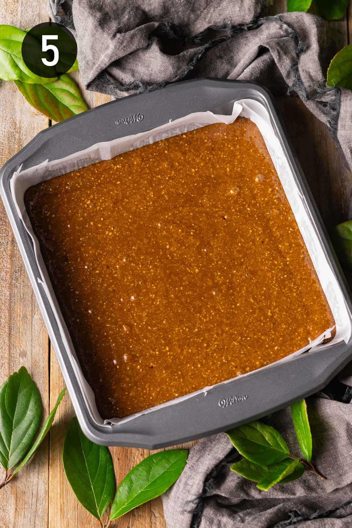 unbaked batter in a square metal tin.