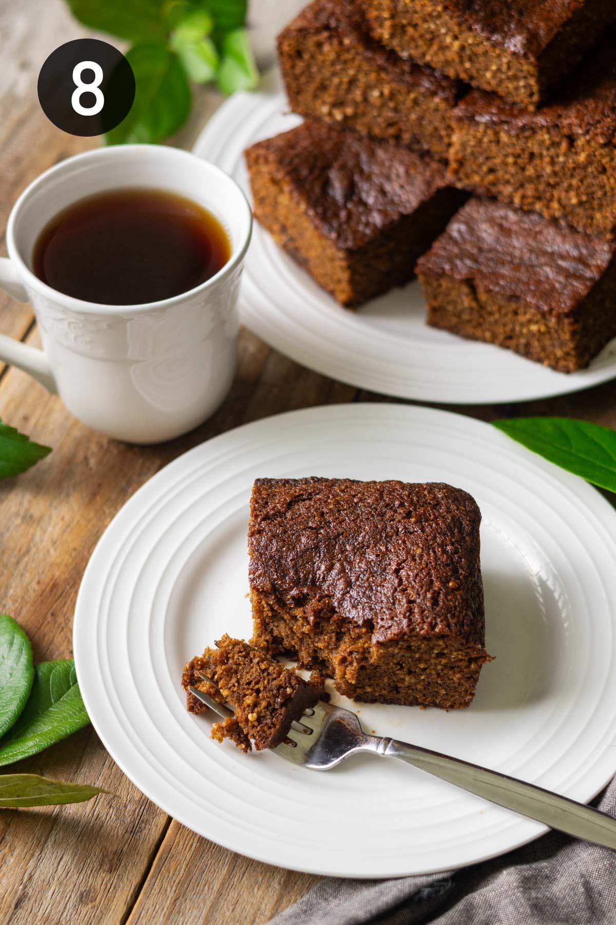 square of parkin on a plate with a cup of tea.