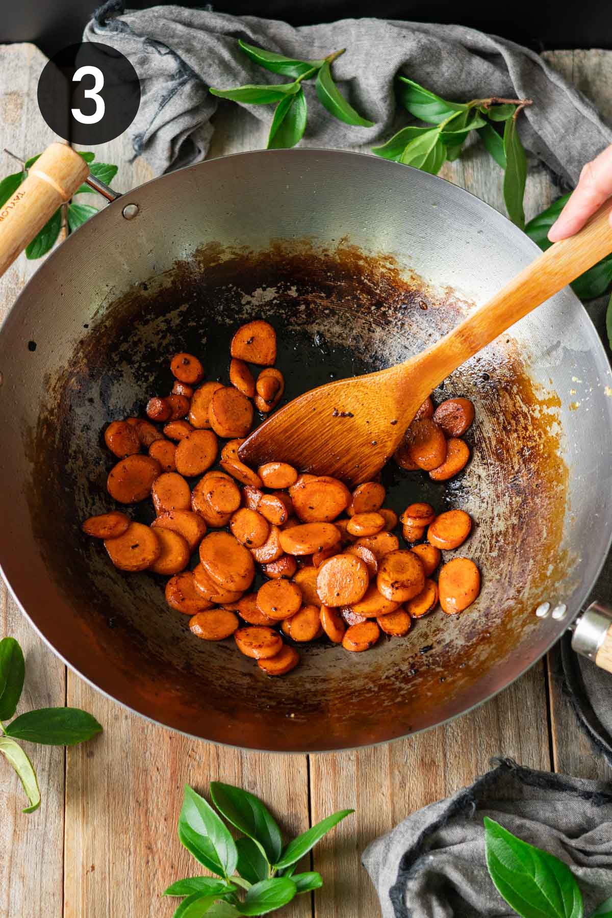 cooking the sliced carrots in the wok.