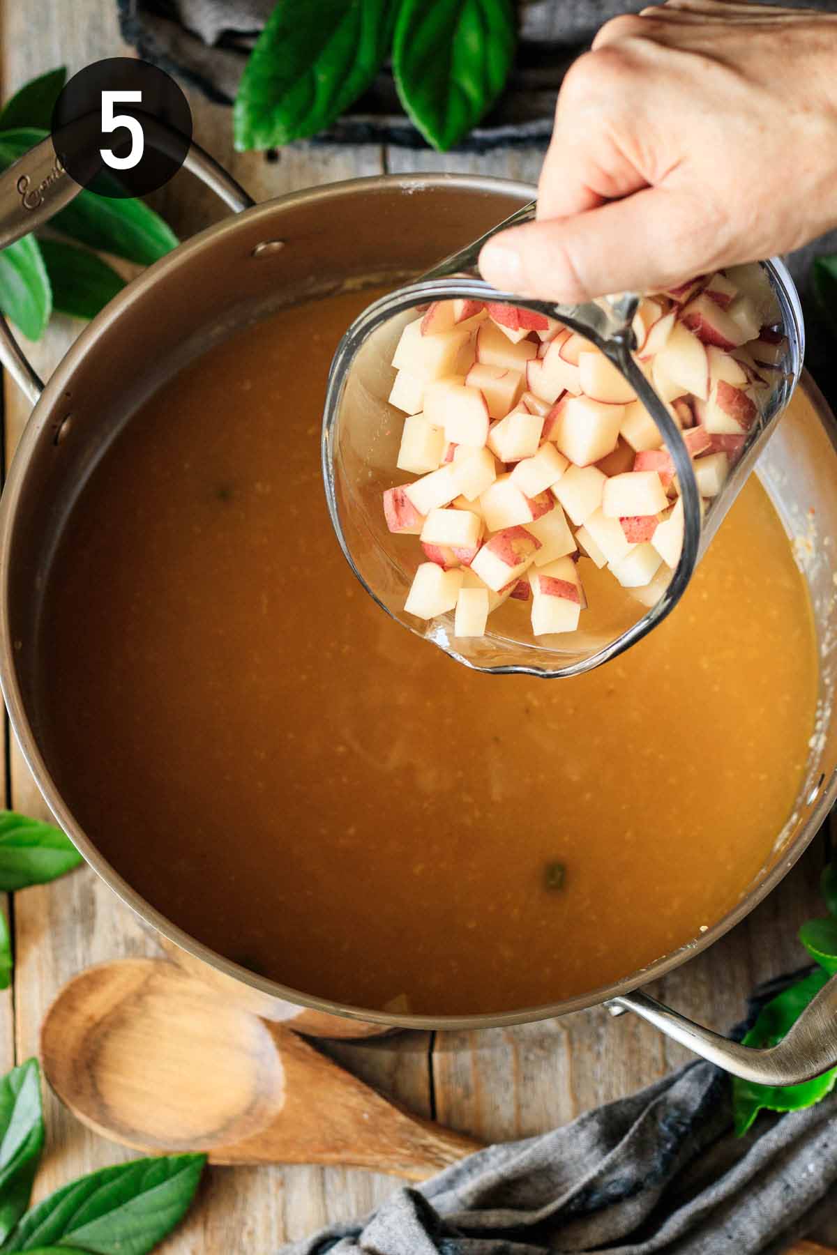 adding cubed potatoes to the chowder.