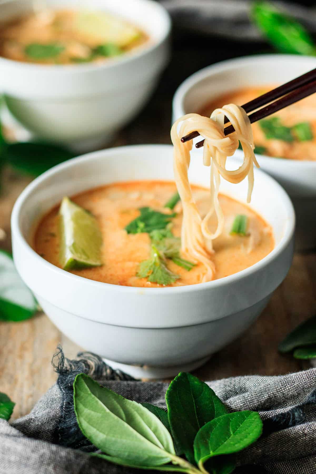 holding noodles on chopsticks.