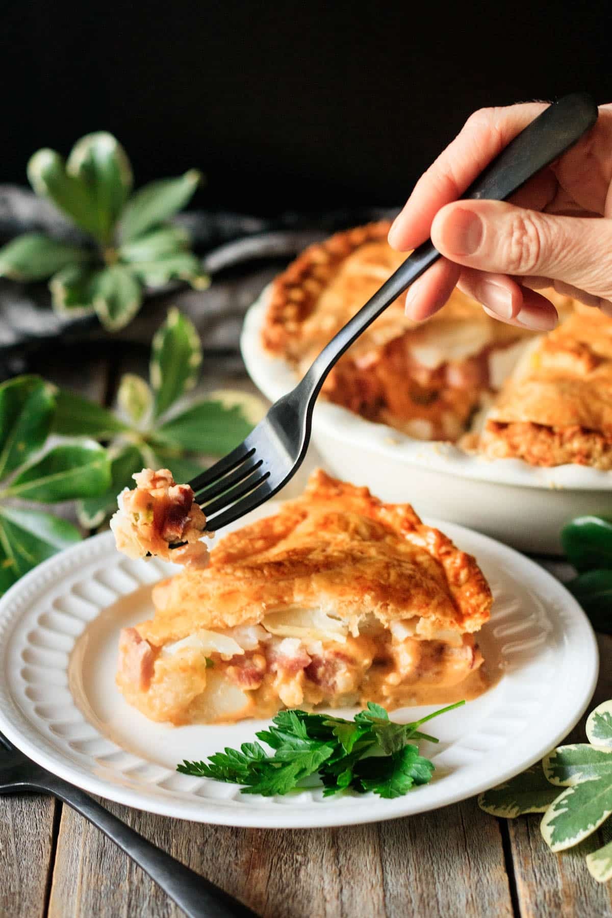 holding a forkful of cheese and ham pie.