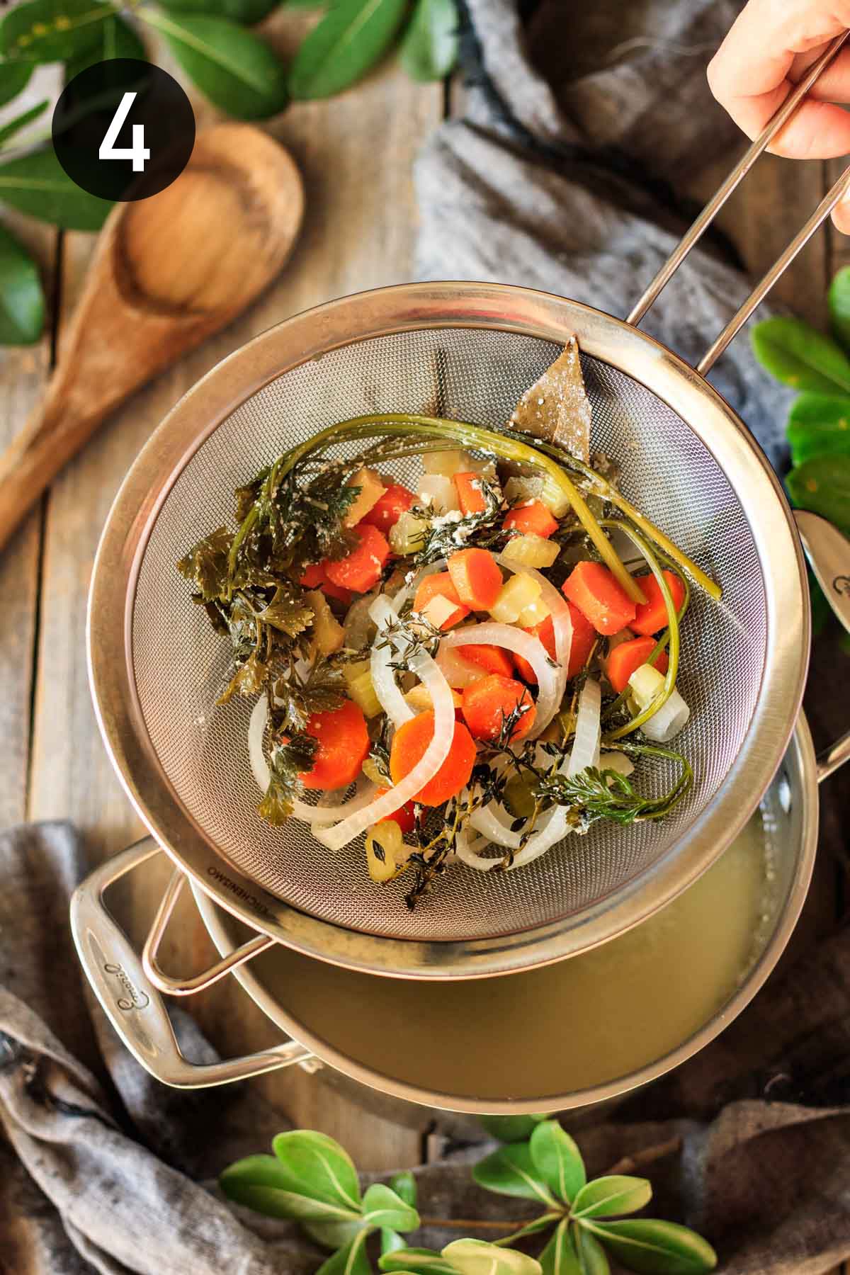 discarding the vegetables strained from the chicken broth.