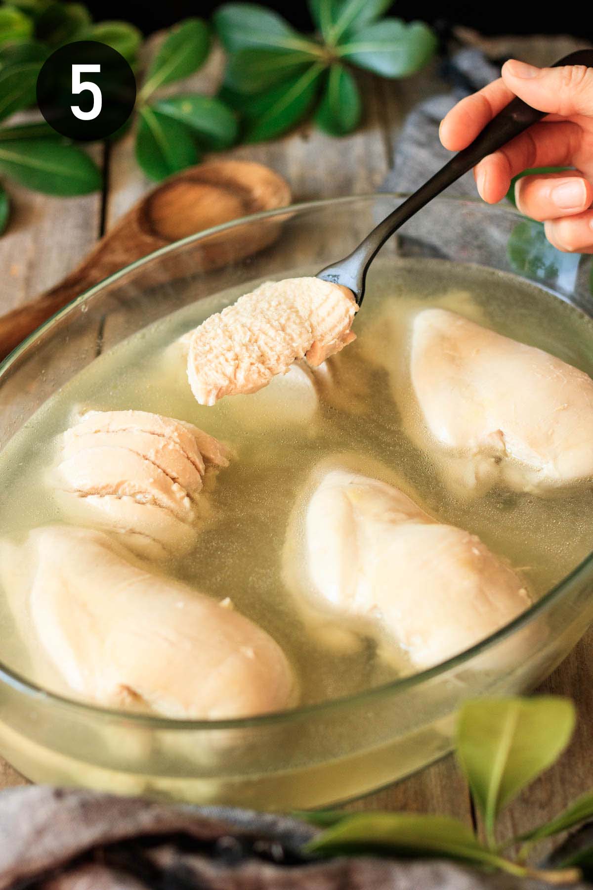 letting the poached chicken cool in chicken broth.