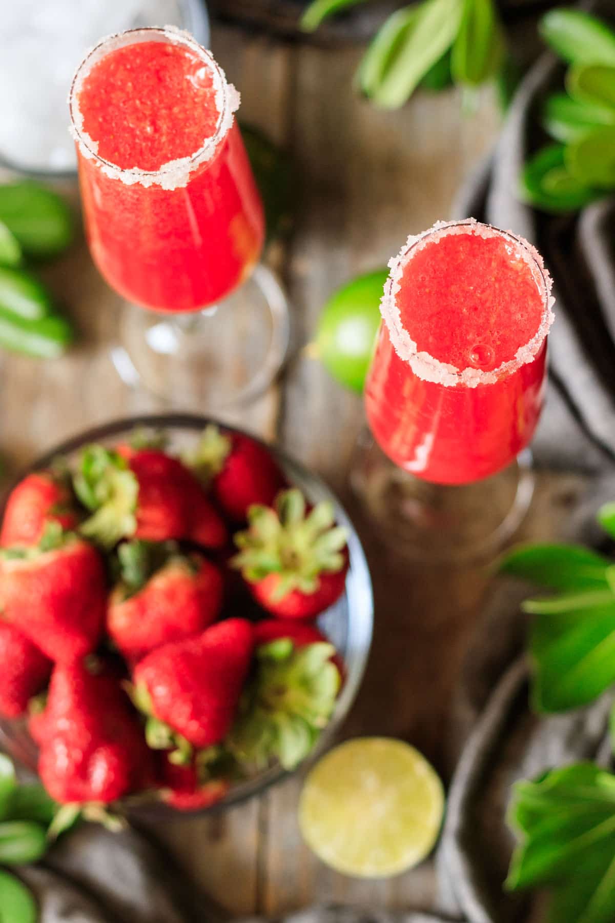 two champagne flutes rimmed with sugar and filled with a strawberry mocktail.
